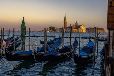 Gondolas moored on sea against church of san giorgio maggiore