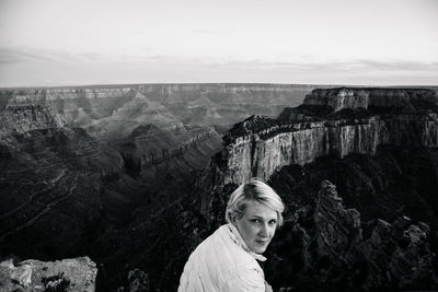 Portrait of woman by rocky mountains at grand canyon against sky