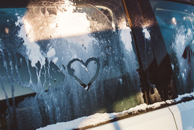 Heart shape on frozen car window during winter
