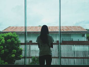 Rear view of woman standing against building