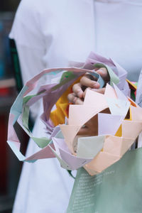 Midsection of woman holding paper crowns