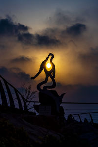 Low angle view of silhouette statue against sky during sunset