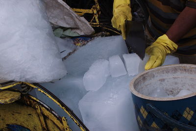 Cropped hands cutting ice