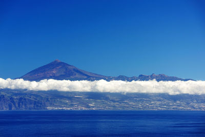 Scenic view of mountain against blue sky