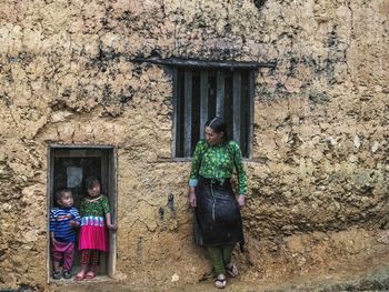 Woman standing by window of building