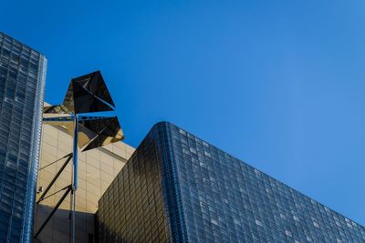 Low angle view of modern building against clear blue sky