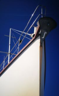 Low angle view of telephone pole against clear blue sky