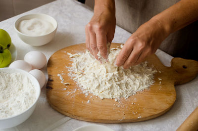 Cropped hand of person preparing food on table