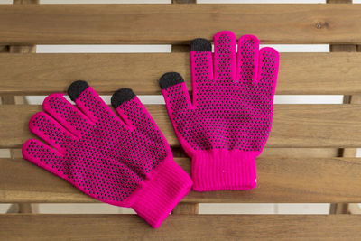Directly above shot of pink gloves on wooden table