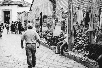 Rear view of man walking on street in city