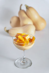 Close-up of orange fruit on table against white background