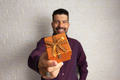 Portrait of smiling man standing against wall