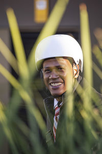 Latino ethnic businessman with bicycle helmet smiling looking at camera.