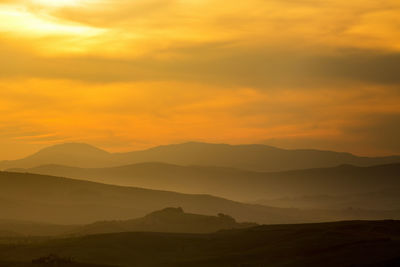 Scenic view of silhouette mountains against sky during sunset