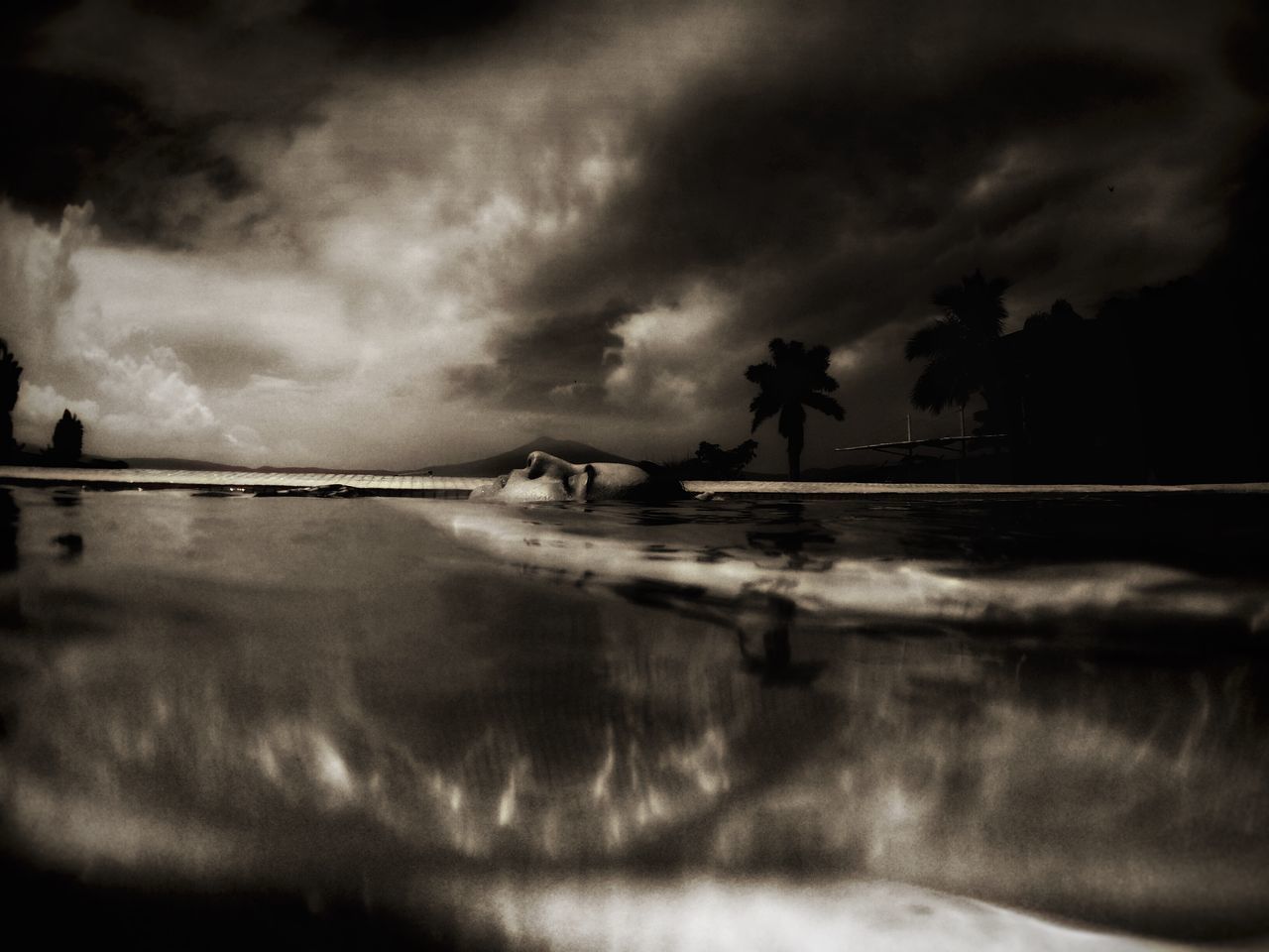 SILHOUETTE OF MAN IN BOAT AT SEA