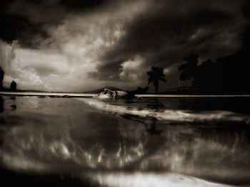 Silhouette of man in boat against dramatic sky