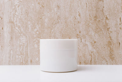 Close-up of tea cup on table against wall