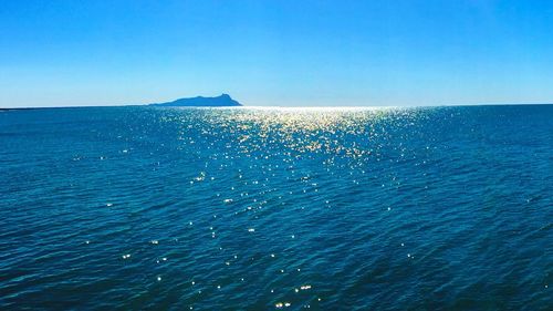 Scenic view of sea against clear blue sky