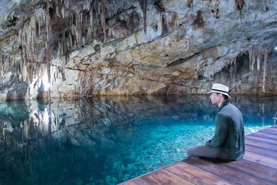 Man sitting at poolside in cave