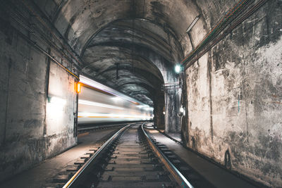 Long exposure image of railroad tracks in tunnel