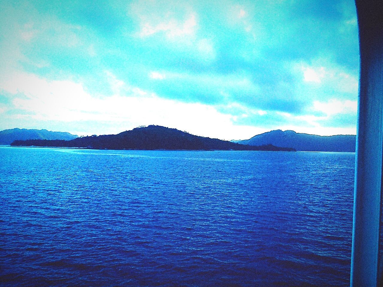 SCENIC VIEW OF SEA WITH MOUNTAINS IN BACKGROUND