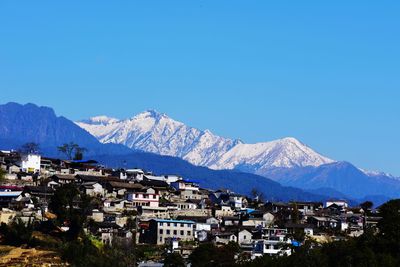 Houses in town against clear blue sky