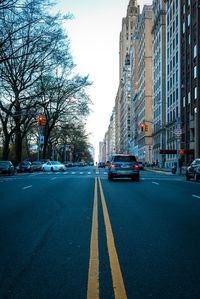 Cars on road against sky in city