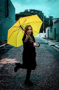 Full length of woman standing on wet rainy day