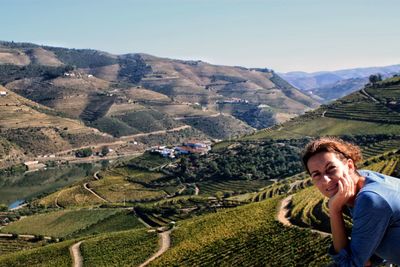 Portrait of mid adult woman standing on terraced field against clear sky