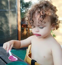 Close-up of shirtless girl eating food at table