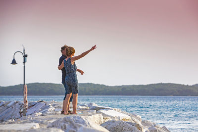 Woman standing at beach against clear sky