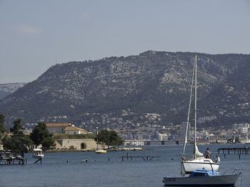 Sailboats in sea against sky