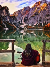 Young woman playing guitar in front of the mountains