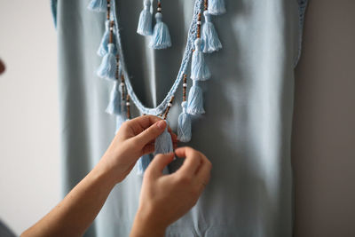 Woman trying on a tunic for the beach, concept of vacation fees, a handmade fringed tunic 