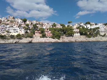View of townscape by sea against sky