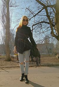 Portrait of woman standing by bare tree