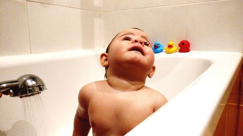 Baby boy playing with ball in bathroom