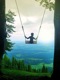 Girl on a swing, beautiful mountain view