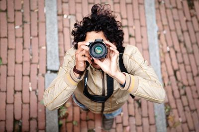 High angle view of man photographing with camera on street