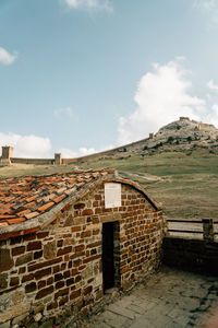 Stone wall of historic building against sky