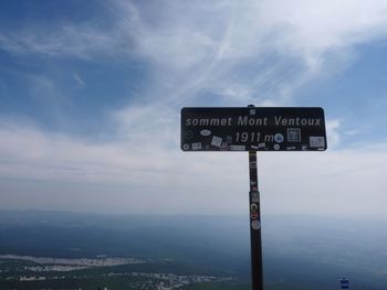 Low angle view of road sign against cloudy sky