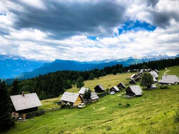 Scenic view of field and houses against sky