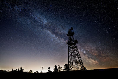 Low angle view of silhouette tower against sky at night - milky way