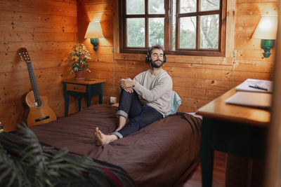 Midsection of man sitting on table at home