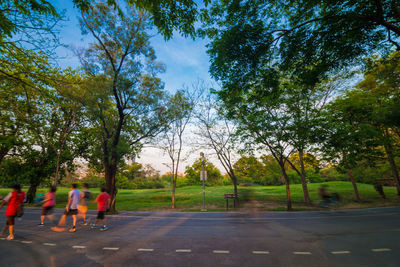 Rear view of people walking on road