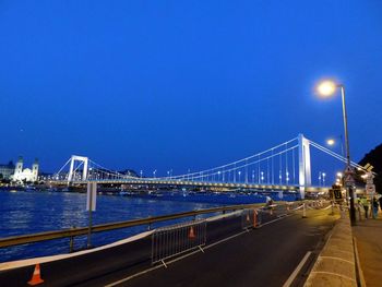 Illuminated bridge over river at night