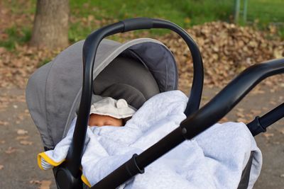 Closeup of stroller with newborn baby in park