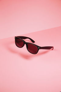 Close-up of sunglasses against pink background