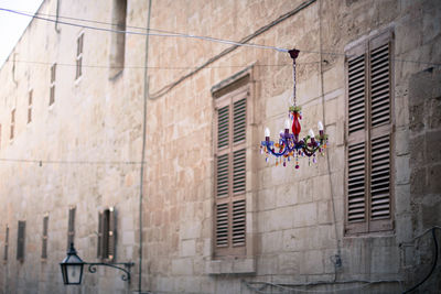 Low angle view of chandelier hanging against building