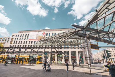 People on street against buildings in city